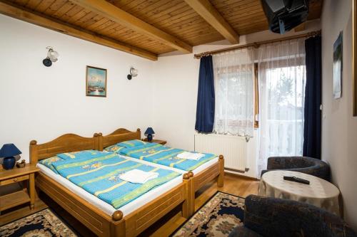 a bedroom with a bed and a table and a window at Villa Jäger in Vonyarcvashegy