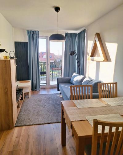 ein Wohnzimmer mit einem Sofa und einem Tisch in der Unterkunft Apartament Złoty Trójkąt z miejscem w garażu podziemnym in Serock