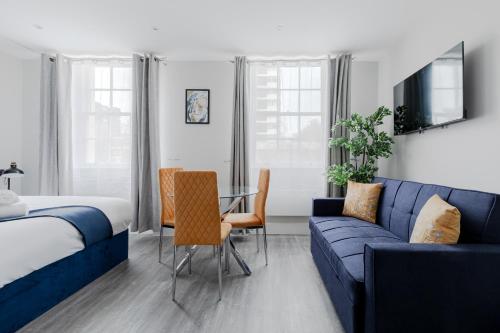 a hotel room with a bed and a blue couch at London Central Studios in London