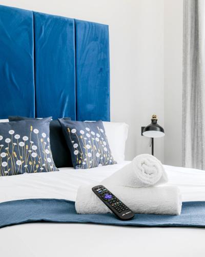 a bed with towels and a remote control on it at London Central Studios in London