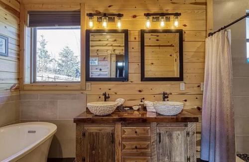 Baño de madera con 2 lavabos, bañera y tubermott en Hawk’s View Log Cabin -Mountains in Gatlinburg. en Gatlinburg