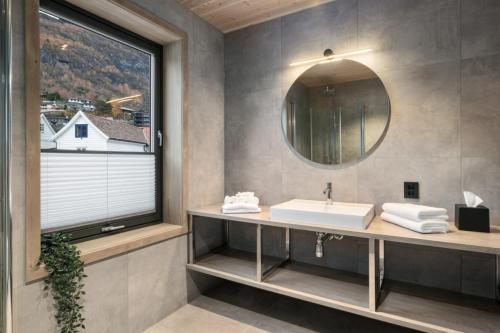 un bagno con lavandino, specchio e finestra di Wangen Apartments AS ad Aurland