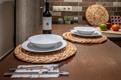 a table with two plates and a bottle of wine at Loutraki Hidden Gem IV in Loutraki