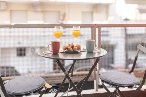 a table with a plate of food and two glasses of orange juice at Loutraki Hidden Gem IV in Loutraki