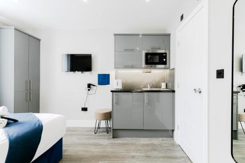 a bedroom with a bed and a kitchen with a microwave at London Central Studios in London