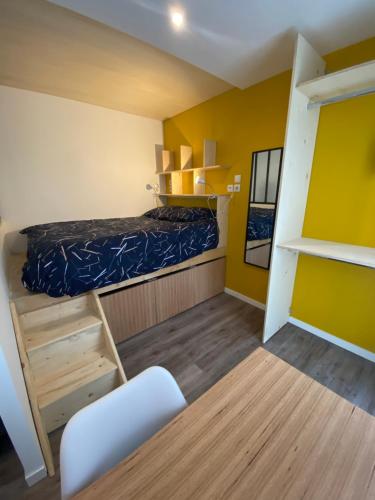 Cette petite chambre comprend un lit et une échelle. dans l'établissement Studio neuf avec jardin privatif, à Bouguenais