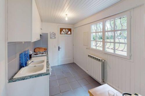 une cuisine avec un évier et une fenêtre dans l'établissement POASANA, à Saint-Julien-en-Born