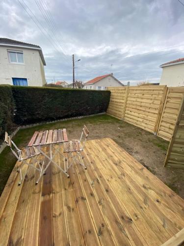 un banc installé au-dessus d'une terrasse en bois dans l'établissement Studio neuf avec jardin privatif, à Bouguenais