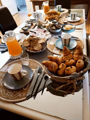 a breakfast table with pastries and coffee and orange juice at La Douce Parenthèse B&B entre bois et champs-Accueil motards in Montirat