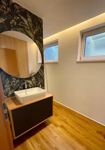 a bathroom with a sink and a mirror at SONNENWEG Designwohnung mit Gartenblick in Plauen