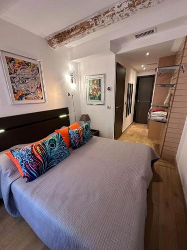 une chambre avec un grand lit avec des oreillers colorés dans l'établissement Cannes Vieux Port splendide vue, à Cannes