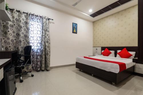 een slaapkamer met een bed met rode kussens bij H R G DESTINY in Indore