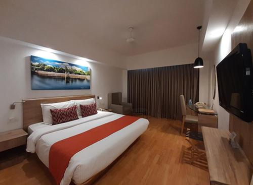 een slaapkamer met een groot bed en een flatscreen-tv bij H R G DESTINY in Indore