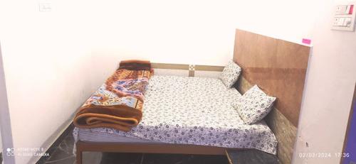 - un petit lit avec une couverture dans l'établissement Hotel Krishna Inn, à Hindaun