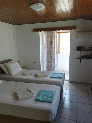 two beds in a room with a window at My Sisters House in Agios Nikolaos