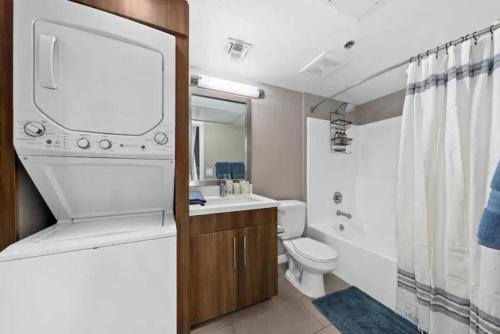 La salle de bains est pourvue de toilettes, d'un lavabo et d'un miroir. dans l'établissement Gem 2-Story Retreat Private Rooftop Terrace, Pool., à Los Angeles