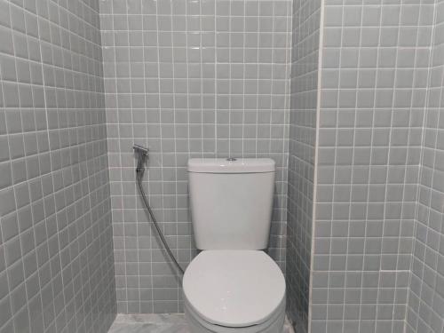 La salle de bains est pourvue de toilettes blanches et d'un mur carrelé. dans l'établissement RB6: StreetFood jay-o Samyan/chinaTown/mrt, à Bangkok