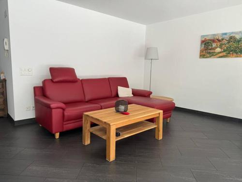 ein Wohnzimmer mit einem roten Sofa und einem Couchtisch in der Unterkunft Appartamento fronte lago in Muralto