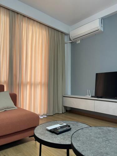 a living room with a couch and a flat screen tv at Shehapi apartment in Kavajë