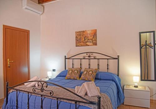 Schlafzimmer mit einem Bett mit blauer Decke in der Unterkunft Casa Celeste in Noto
