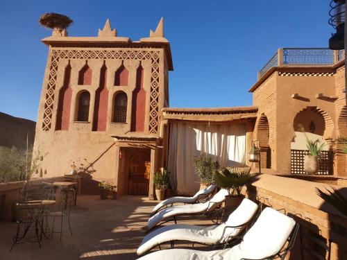a group of chairs sitting outside of a building at Dar Jnan Tiouira Dades in Tamellalt