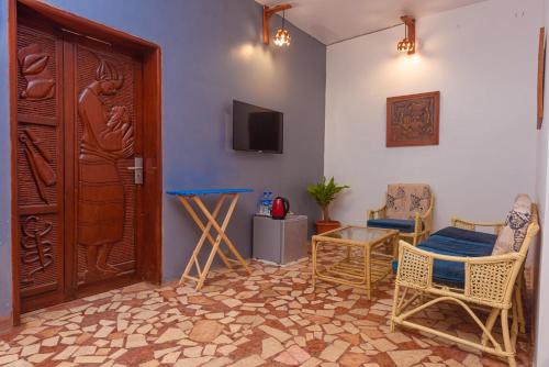 Habitación con puerta, mesa y sillas en Bonsai Boutique Homes en Ibadán