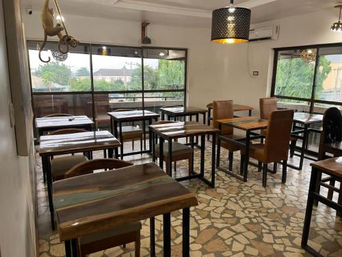 un restaurante con mesas de madera y sillas en una habitación en Bonsai Boutique Homes en Ibadán