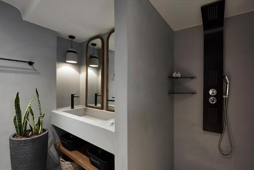 a bathroom with a sink and a mirror at The Sand Villa in Agios Nikolaos
