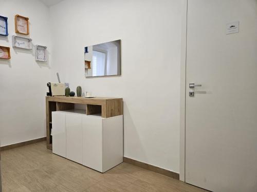 Habitación blanca con mesa y espejo. en Santalucia Suite en Modugno