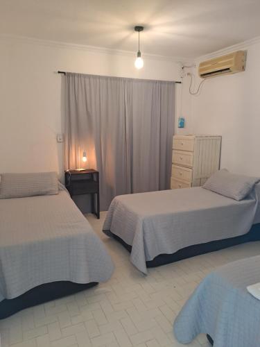 a bedroom with two beds and a dresser at Casa Aconchego in Paso de los Libres