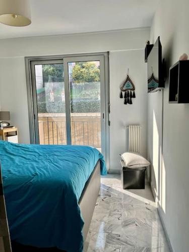 - une chambre avec un lit bleu et une porte coulissante en verre dans l'établissement Beau 2 pièces,Terrasse, Parking Menton Centre, à Menton