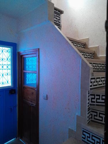 a room with a staircase with a door and a window at Casa Lotfi 1 in Chefchaouene