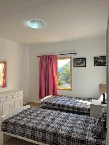 Un dormitorio con dos camas y una ventana en Villa Touristic Village Nr 7030, en Hurghada