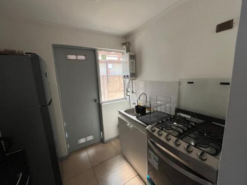 a small kitchen with a stove and a sink at Casa en Villa Galilea in Curicó