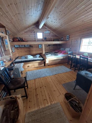 una habitación con 2 camas y una mesa en una cabaña en Lakeside Holiday Cottage near Ivalo - Minna-Carita's, en Ivalo