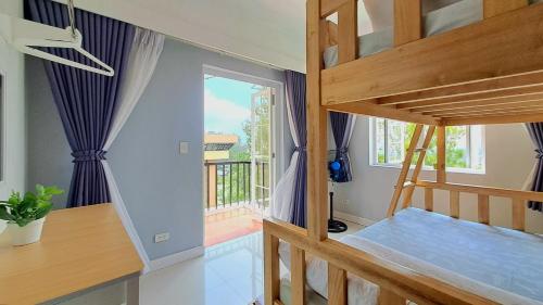 a room with two bunk beds and a balcony at 88 Gibraltar (Mines View) in Baguio