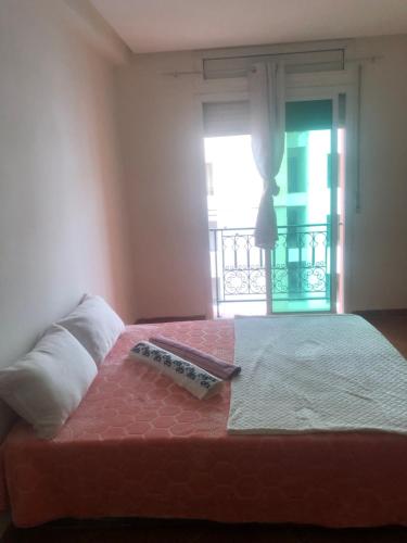 - un lit avec une télécommande et une fenêtre dans l'établissement Pure immobilier, à Aït Saïd