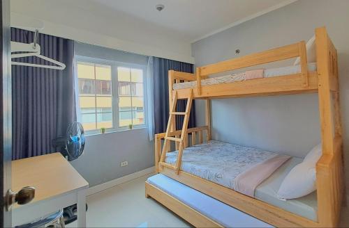 a bedroom with two bunk beds and a desk at 88 Gibraltar (Mines View) in Baguio
