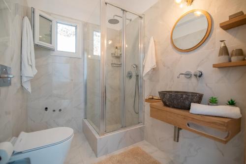 a bathroom with a shower and a sink at Nèsoi Villas Naxos in Naxos Chora