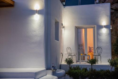 a white building with a porch with a table and chairs at Nèsoi Villas Naxos in Naxos Chora