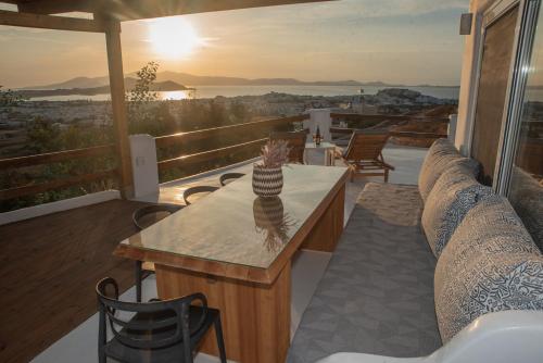 a porch with a couch and a table on a balcony at Nèsoi Villas Naxos in Naxos Chora