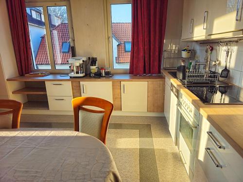 una cocina con armarios blancos y una mesa con mesa en Helle Wohnung mit sonnigem Ausblick, in zentraler Lage 135 qm, 4 Zimmer Wohnung, en Oldenburg
