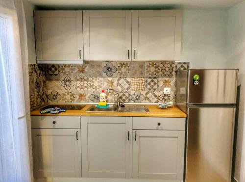 cocina con armarios blancos y nevera de acero inoxidable en Nikiti Spathies Resort - Double Bedroom Sofita en Kalogria