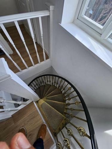 a person is walking down a spiral staircase at Nice and Cosy One Bed Flat in Carshalton