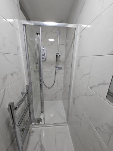 a shower with a glass door in a bathroom at Nice and Cosy One Bed Flat in Carshalton