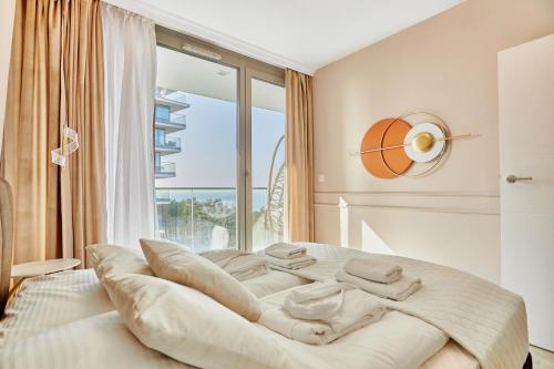 a bedroom with a large bed with a large window at Wave - Aurum II Apartment - Front Sea View in Międzyzdroje