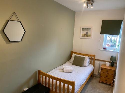 a small bedroom with a bed and a mirror at Spacious single and double bedroom in Southampton with free parking in Southampton