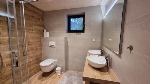 a bathroom with two toilets and a glass shower at Chalets Hrabovo in Ružomberok