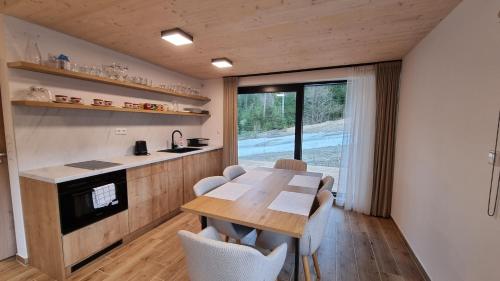 eine Küche und ein Esszimmer mit einem Holztisch und Stühlen in der Unterkunft Chalets Hrabovo in Ružomberok