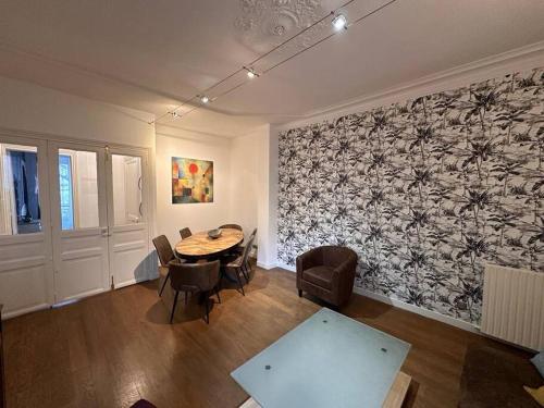 Cette chambre comprend une table, des chaises et un mur. dans l'établissement So Chic 72 Montmatre Apartement d’Exception, à Paris